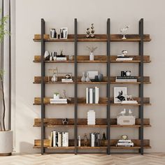 a book shelf with many books on top of it in a living room next to a potted plant