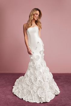 a woman in a white wedding dress with roses on it