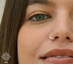 a close up of a woman with a nose piercing on her nose and the bottom part of her nose