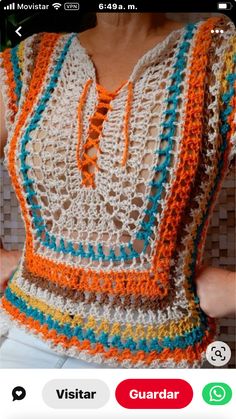 a woman wearing an orange and white crochet top with blue, yellow, and green trim