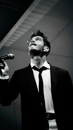 a man in a suit singing into a microphone