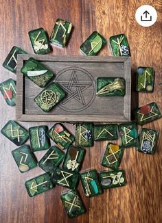 green and gold dice set with celtic symbols on the board, next to it is a wooden box