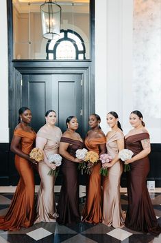 a group of women standing next to each other in front of a door holding bouquets