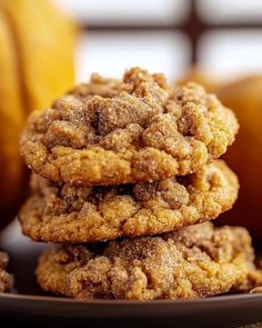 three cookies stacked on top of each other in front of some oranges and bananas