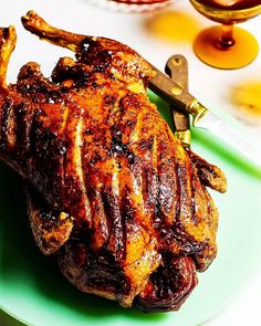 a piece of meat sitting on top of a green plate next to a knife and fork