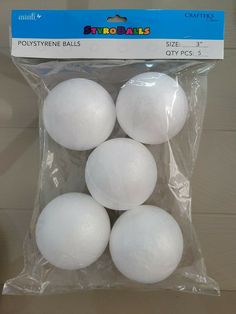 four white plastic balls sitting in a package