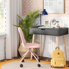 a desk with a yellow backpack sitting on top of it next to a potted plant