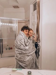 a man and woman wrapped in blankets taking a selfie