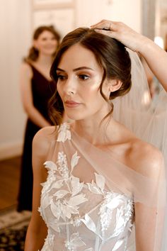 a woman in a wedding dress getting ready for the ceremony with her hair and makeup done