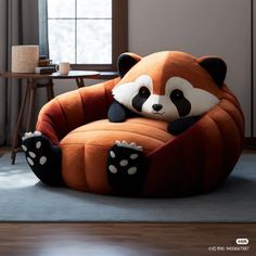 a large stuffed panda bear sitting on top of a pumpkin shaped chair in a living room