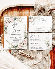 the wedding stationery is laid out on a wooden tray