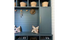 a blue shelf with shoes and hats on it next to a wall mounted coat rack