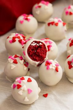 white chocolates with red and pink sprinkles are arranged on a table