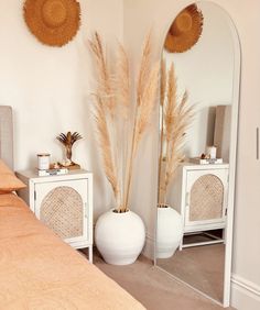 a bed room with a large mirror and two vases