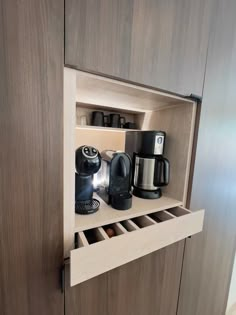 an open cabinet with coffee maker and other items in it