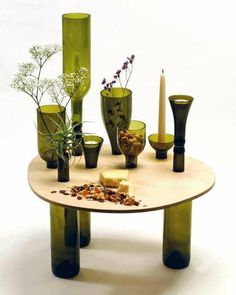 a table with vases and candles on top of it in front of a white background