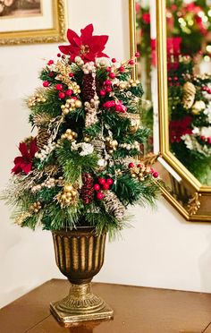 a potted christmas tree with red and white poinsettis in it sitting on a table