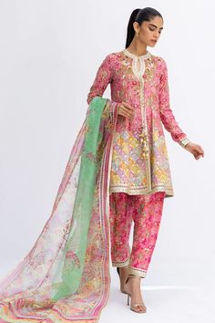 This short, aurora pink angarkha is the embodiment of a classy yet charming festive look. It is rendered with a thoughtful arrangement of zardoze and gota work on a floral-printed khaddi silk, featuring a chatapatti border. A multi-coloured dupatta with gota finishing and a printed shalwar add the final touches to this Printed Suits Design Pakistani, Printed Suits Design, Anarkali Lehenga, Lace Dress Design, Gota Work, Suits Design, Festive Look, Classy Dress Outfits, Pakistani Dress Design