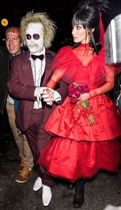 two people dressed up in costumes walking down the street