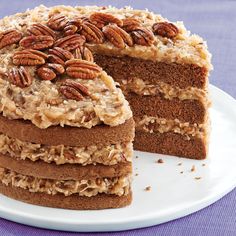 there is a cake with pecans on top and one slice cut out from it