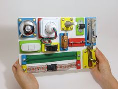 a person holding up a multicolored case with various items attached to the back