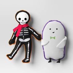 two decorated cookies in the shape of halloween characters, one with a skeleton on it