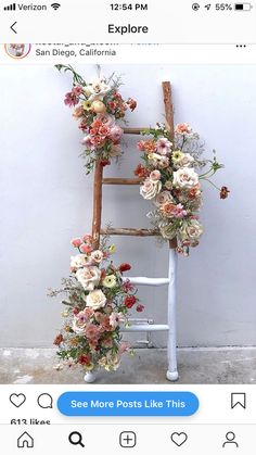 an old ladder decorated with flowers and greenery