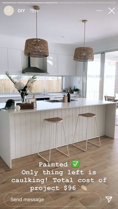 a kitchen with two stools in front of the island and an advertisement on the wall