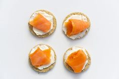 four crackers with cream cheese and salmon on them are arranged in the shape of a circle