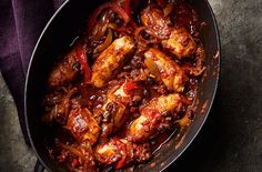 a pan filled with meat and sauce on top of a table