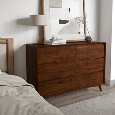 a bedroom scene with focus on the dresser and bed sideboard in the foreground