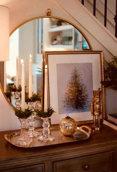 a christmas scene with candles and pictures on a table in front of a staircase case