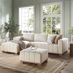 a living room scene with focus on the sofa and footstool in the center