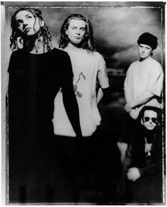 black and white photograph of three men with long hair, one wearing a t - shirt