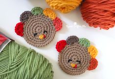 two crocheted turkeys sitting next to yarn