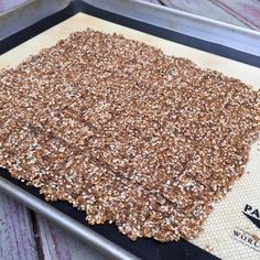 a baking pan filled with granola on top of a wooden table