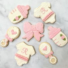 decorated cookies in the shape of baby shoes and booties on a marble table top