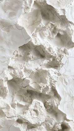 a white rock wall with cracks in it