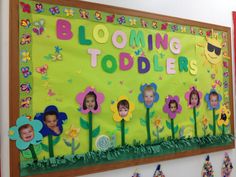 a bulletin board with pictures of children's faces and the words blooming toddlers