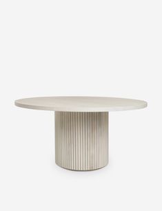 a round table with a white top and silver stripes on the base, in front of a