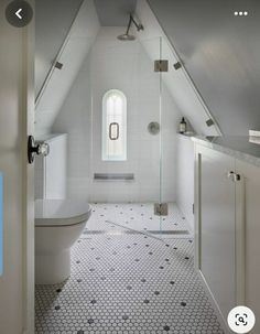 a bathroom with a white toilet sitting under a window