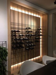 there is a wine rack with many bottles on it in the room next to two sinks