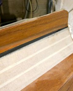 a close up of a wooden bench with no one on it's seat cushion