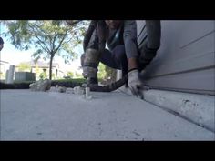 a man is working on the side of a building with his feet in the air