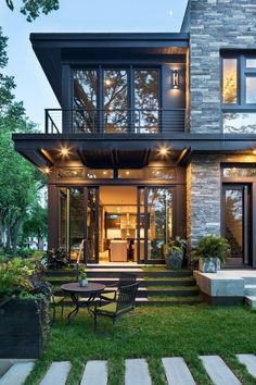 a modern house with large windows and stairs leading up to it