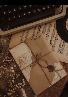 an old book is tied with string and surrounded by music sheets, notes, and a typewriter