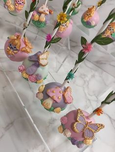 there are many cake pops decorated with animals and flowers