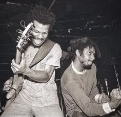 two young men playing instruments in front of a crowd