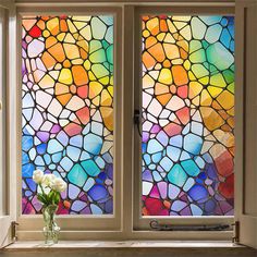 two stained glass windows with flowers in the vase on the window sill next to them