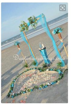 an arrangement of flowers and decorations on the beach